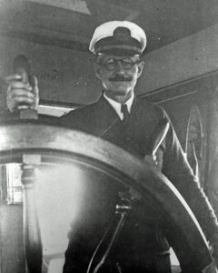 Captain Reubin A. Garlick at the helm of the Hammonton